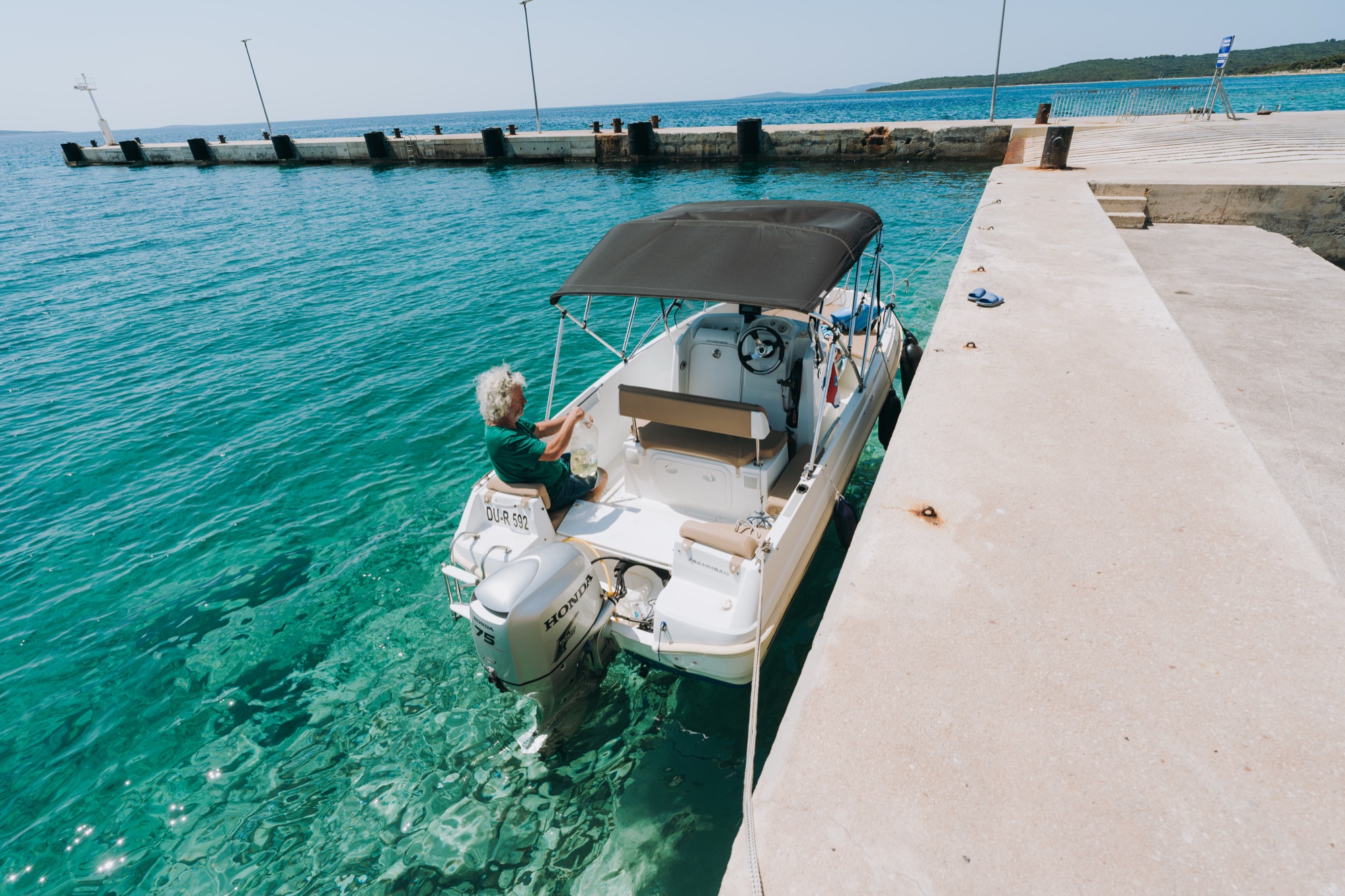 A small motorboat moored at the quay on neighbouring Silba