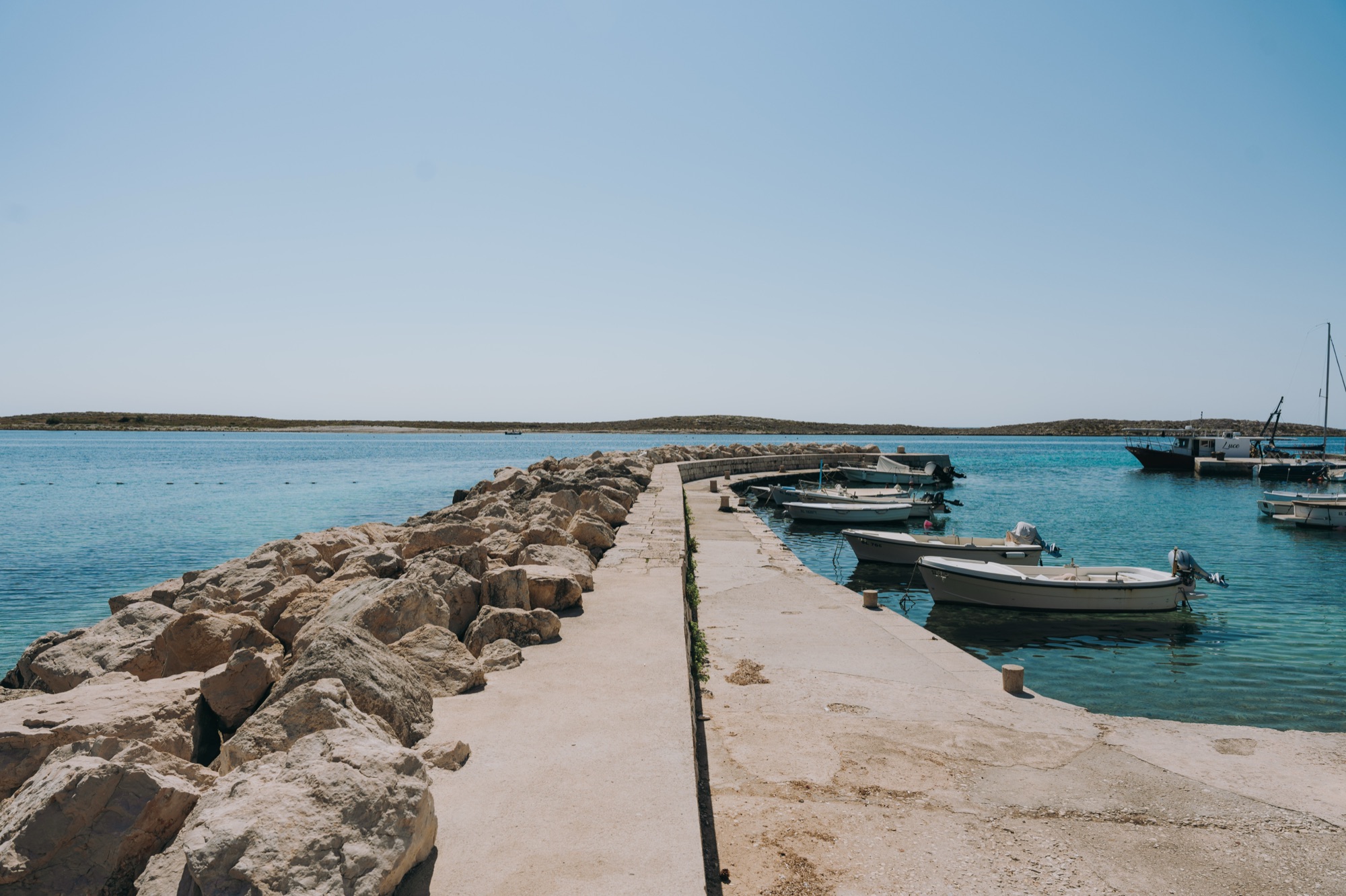 The old harbour of Premuda with boats along the breakwater
